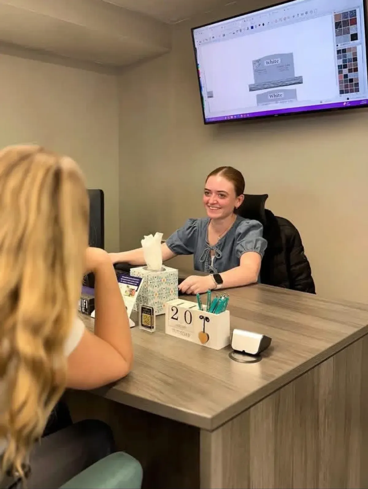 A Utah Headstone Design consultant helping a family plan a memorial at her design desk